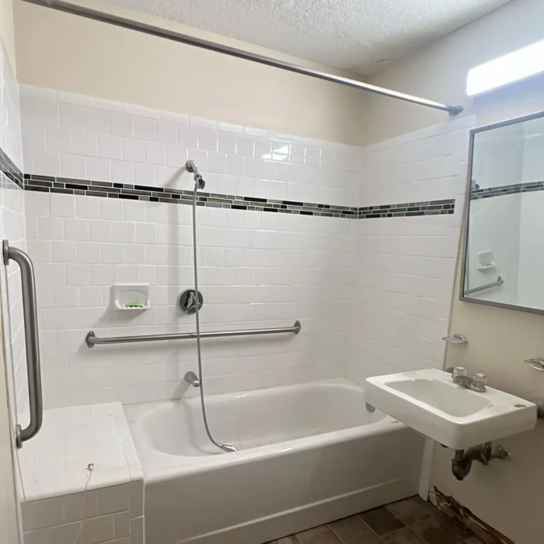 The same bathroom emptied, tub and sink clean with nothing left on the floor
