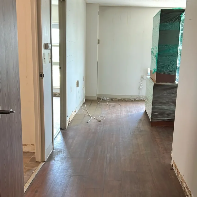Cleared hallway with swept hardwood floor after the cleanout