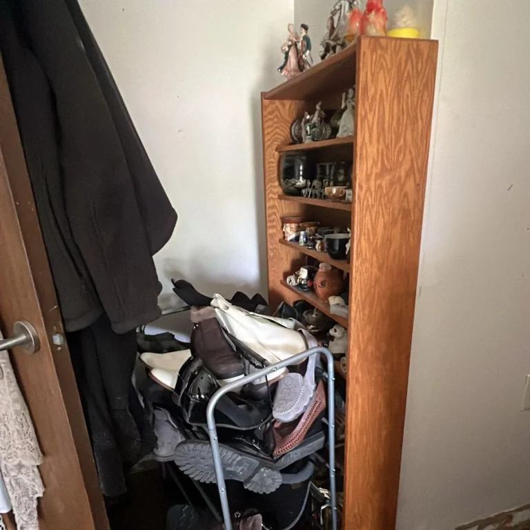 Shelving unit stacked with boxes, bags and household items